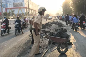 CSGT đẩy xe cút kít đổ bùn đất cho dân khỏi trượt