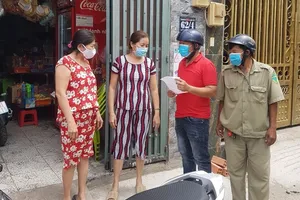 Cán bộ phường Bình Hưng Hòa A, quận Bình Tân, vận động người dân đeo khẩu trang. Ảnh: LÊ THOA 