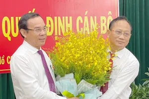 Bí thư Thành uỷ TP.HCM Nguyễn Văn Nên tặng hoa chúc mừng ông Trần Văn Nam. Ảnh: Web Thành uỷ 