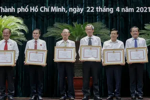 Lãnh đạo báo Pháp luật TP.HCM (bìa phải) nhận bằng khen của Chủ tịch UBND TP.HCM. Ảnh: NGUYỆT NHI