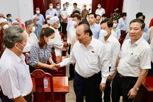 Chủ tịch nước Nguyễn Xuân Phúc hỏi thăm cử tri quận 5, 8, 11, trước thềm buổi tiếp xúc. Ảnh: HOÀNG GIANG