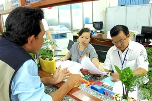 Cán bộ tư pháp phường Bình Hưng Hoà A, quận Bình Tân tất bật với các thủ tục sao y, trích lục cho người dân. Ảnh: LÊ THOA