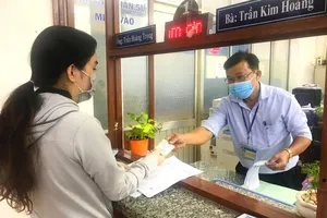 Cán bộ phường ở TP.HCM làm thủ tục sao y chứng thực cho người dân. Ảnh: LÊ THOA