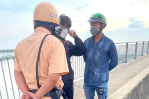 CSGT TP.HCM tiếp cận ngăn cản thanh niên định nhảy cầu Phú Mỹ. Ảnh: NSG