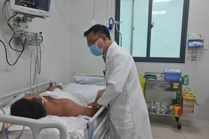 Bác sĩ BV Chợ Rẫy đang thăm khám cho bệnh nhân ngộ độc botulinum. Ảnh: NGUYỄN CHÂU