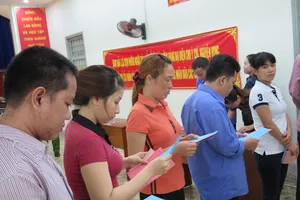 Cử tri là can phạm tại trại tạm giam Chí Hòa chăm chú dò lại thông tin ứng cử viên để tiến hành bầu cử