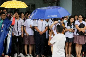 Xúc động cảnh bố mẹ dầm mưa đón con sau giờ thi ở Sài Gòn