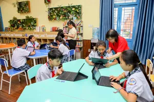 Cô Nguyễn Thị Ánh Nga (Phó Hiệu trưởng Trường Tiểu học Lê Đức Thọ, quận Gò Vấp) cùng các học sinh trong phòng thư viện thông minh. Ảnh: NGUYỆT NHI