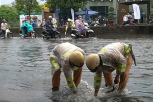 CSGT lội nước giúp người dân khơi miệng cống chống ngập