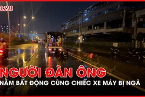 Người đàn ông nằm bất động trong làn ô tô cùng chiếc xe máy bị ngã 