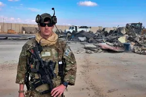 Binh sĩ Mỹ đứng cạnh khi máy ủi dọn đống đổ nát tại căn cứ Ain Al Asad ở Iraq. 