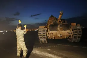 Một binh sĩ Thổ Nhĩ Kỳ hướng dẫn đồng đội lái xe tăng tới vị trí mới ở biên giới Thổ Nhĩ Kỳ-Syria. Ảnh: AP