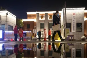 Công nhân đeo khẩu trang trước một bệnh viện dã chiến đã đóng cửa ở TP Vũ Hán, tỉnh Hồ Bắc (Trung Quốc) sau khi những bệnh nhân cuối cùng đã xuất viện. Ảnh: REUTERS