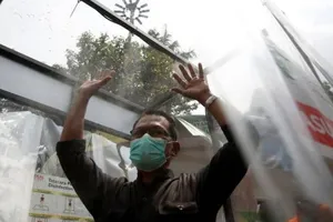 Một đàn ông đeo khẩu trang được xịt khử trùng ở Jakarta, Indonesia. Ảnh: REUTERS