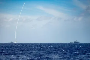 Tàu khu trục USS Barry (trái) phóng tên lửa trong cuộc tập trận bắn đạn thật hôm 19-3. 