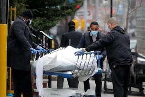 Các nhân viên đẩy một thi thể bên ngoài bệnh viện Brooklyn ở New York (Mỹ). Ảnh: REUTERS