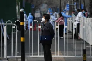 Một phụ nữ đứng đợi ngoài một bệnh viện nhi ở Trung Quốc. Ảnh: AFP