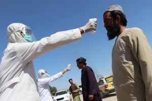 Nhân viên y tế đo thân nhiệt người dân tại Afghanistan. Ảnh: EPA