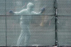 Nhân viên y tế di chuyển một hàng rào đặt trước các xe tải đông lạnh được dùng làm nhà xác tạm thời tại Trung tâm Y khoa Brooklyn ở TP New York.