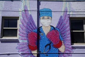 Một bức tranh được vẽ trên tường mô tả một nhân viên y tế ở TP Denver, bang Colorado của Mỹ. Ảnh: AFP