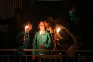 Một gia đình thắp nến ngoài ban công trong lễ Phục sinh ở Athens, Hy Lạp ngày 19-4. Ảnh: REUTERS