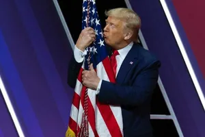 Tổng thống Donald Trump hôn cờ Mỹ. Ảnh: AP