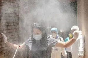 Một phụ nữ được xịt khử trùng ở Nepal. Ảnh: AFP