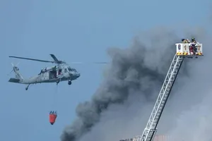 Trực thăng Hải quân Mỹ và lính cứu hỏa San Diego tiếp tục dập lửa trên tàu tấn công đổ bộ USS Bonhomme Richard. Ảnh: REUTERS/Mike Blake