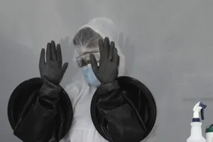 Nhân viên y tế vệ sinh găng tay sau khi làm việc tại điểm xét nghiệm COVID-19 ở biển Miami, bang Florida, Mỹ.