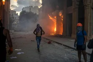 Người biểu tình chụp ảnh một tòa nhà bị đốt cháy.