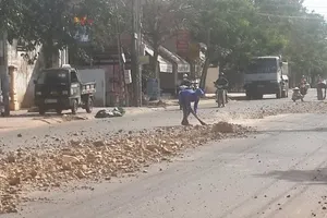 Xe tải đổ đá ra đường, bà con phụ bác tài dọn dẹp