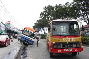 Xe tải bể bánh nằm chổng vó trên dải phân cách