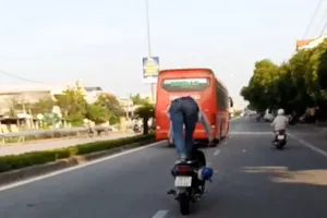 Người đứng trên yên xe máy khi chạy xe bị phạt tiền