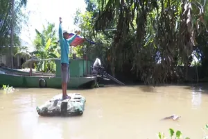 Lão nông chế bè qua sông bằng vỏ chai thuốc bảo vệ thực vật