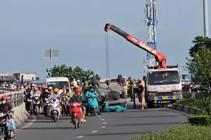 Xe taxi công nghệ bị lật trên cầu vượt Quang Trung