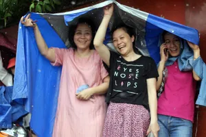 Phụ huynh đội mưa chờ con ngoài phòng thi