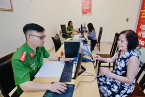 Dân cười tươi khi làm thủ tục hành chính ở công an phường ngày đầu vận hành chính quyền 2 cấp