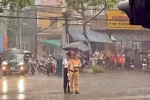 Người dân cầm ô che mưa cho CSGT làm nhiệm vụ A80 