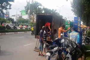 Xe tải lật nhào, hàng chục thùng bia rơi xuống đường Điện Biên Phủ