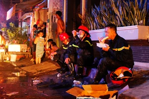 Cảnh sát PCCC ướt đầm, ngồi bệt ăn bánh mì sau vụ cháy kho