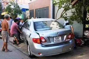 1 phụ nữ lùi ô tô từ nhà ra đường cuốn 4 xe máy vào gầm 