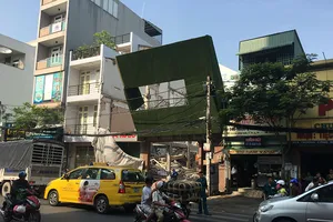 Biển quảng cáo đổ đè trụ điện ở công trình đang tháo dỡ