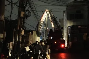 Mái che bị lốc cuốn dính vào đường dây điện ở quận 9