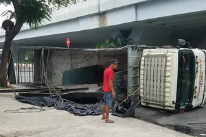 Xe chở máy dập sắt lật trước nhà hàng tiệc cưới ở Bình Tân