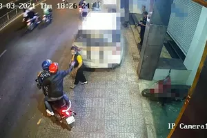 Hai thanh niên bỏ chạy sau khi tạt ca mắm tôm vào người chị T ngay trước trụ sở công ty. Ảnh chụp từ clip