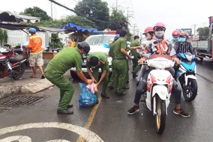 Tháo dỡ chốt ở thị trấn Tân Túc, công an phát nước, bánh mì cho người về quê