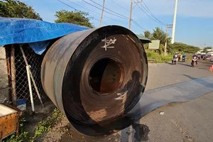 2 cuộn sắt trên xe đầu kéo bị đứt xích giằng, rơi xuống Quốc lộ 1