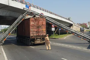 Xe đầu kéo kéo gãy giá long môn trên Quốc lộ 1 rồi va trúng xe buýt