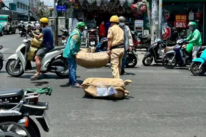 Cán bộ CSGT Tân Bình giúp người dân dọn hàng hóa ở Tân Bình