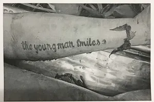 Tìm thân nhân thi thể trôi sông có chữ 'the young man smiles' trên tay